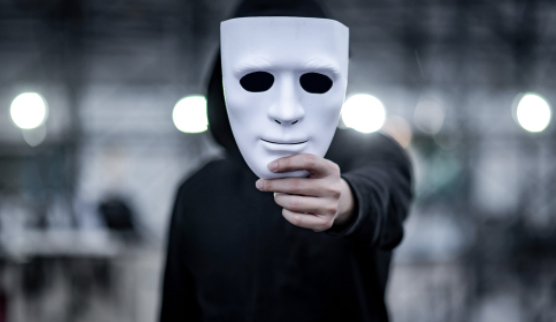 Man holds anonymous mask in front of face