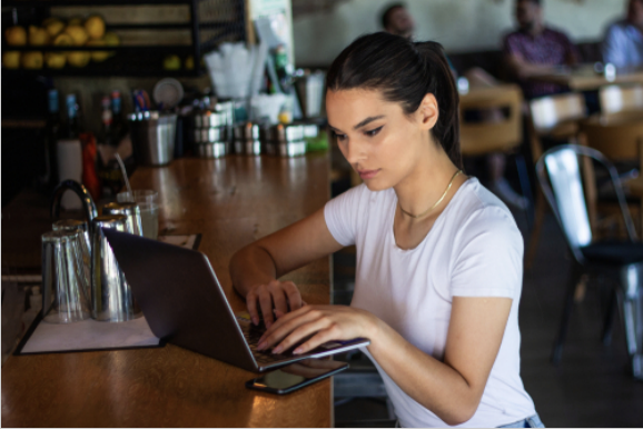 Young woman with coffee cup and laptop at coffe shop